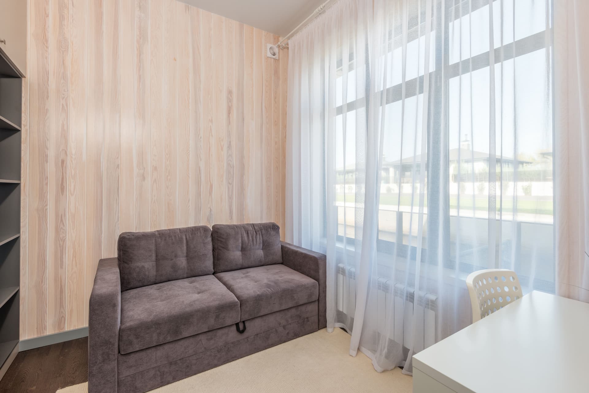 A small apartment living room with a sofa and window