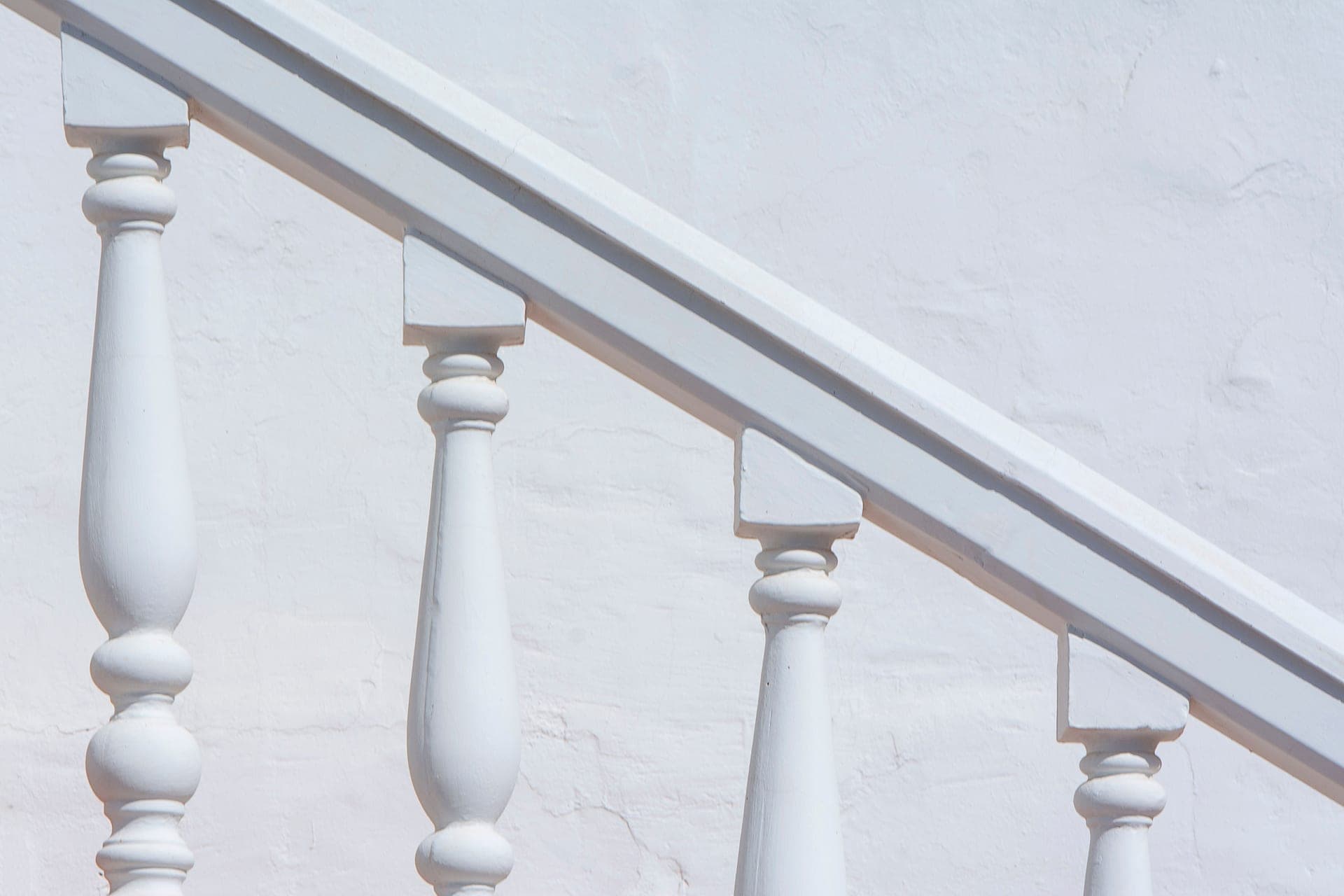 A wooden banister and newel post at the foot of a staircase