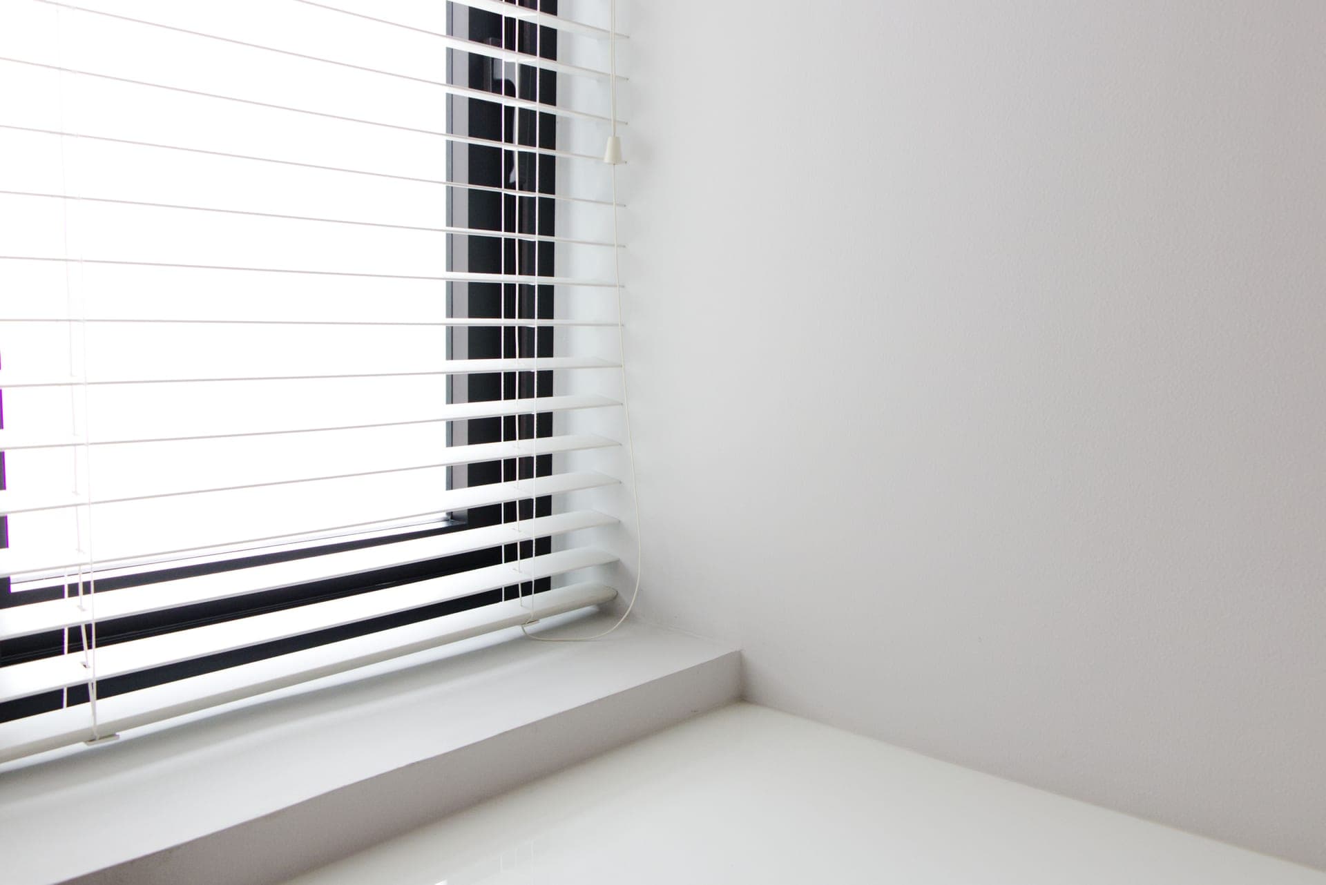 Horizontal window blinds with a cord in a bright room
