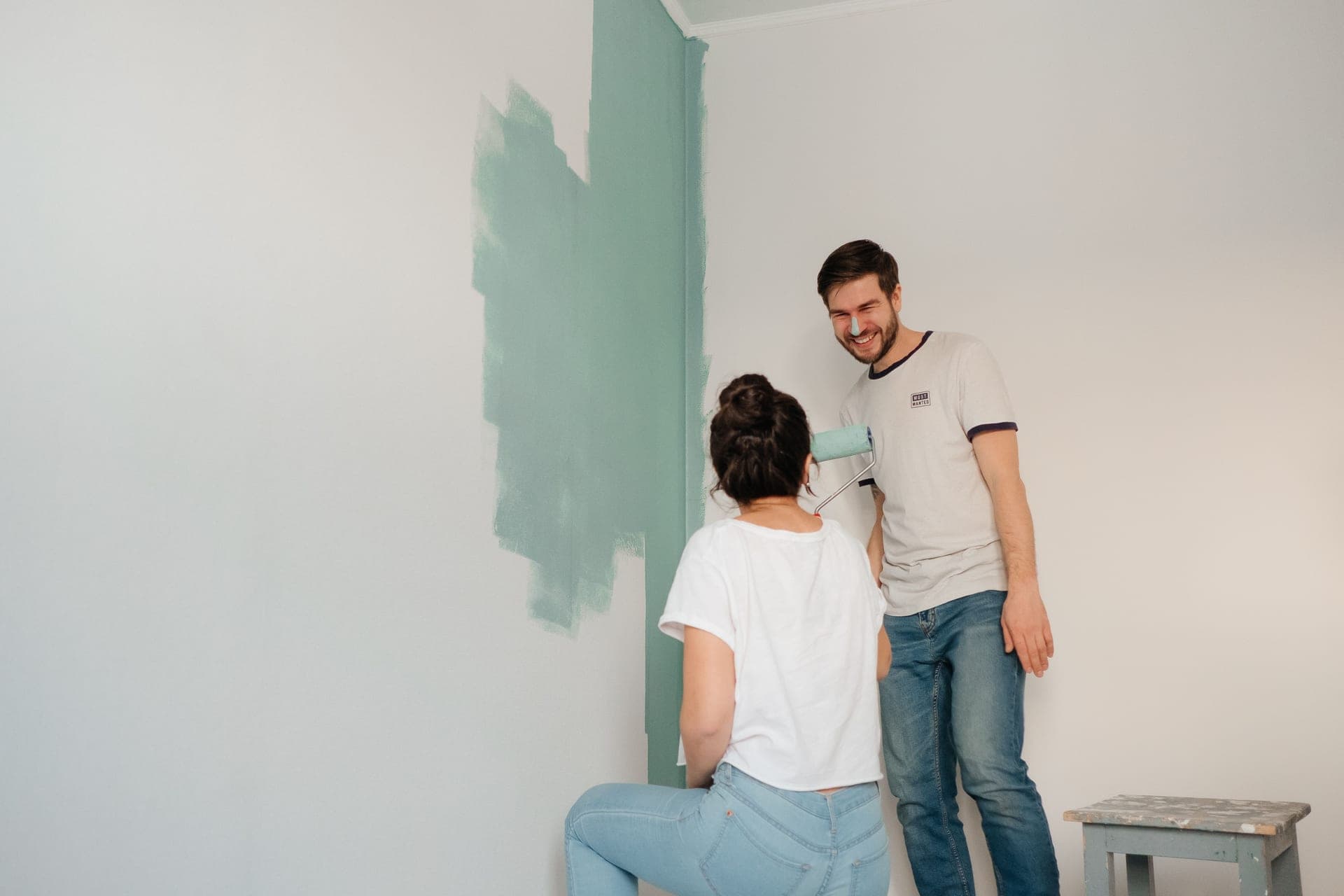 A stud finder held against a painted wall
