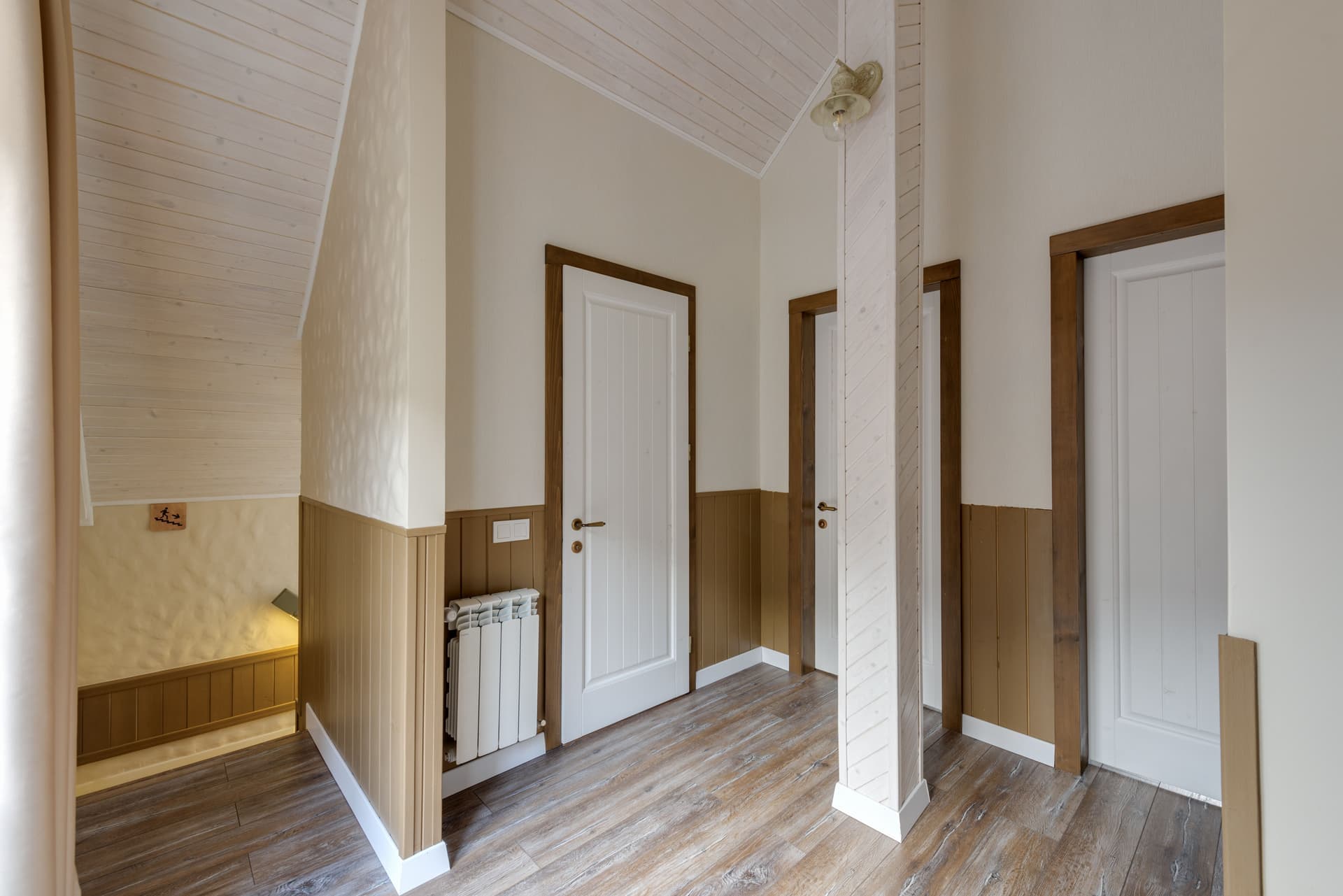 A long hallway with white walls and wooden floors