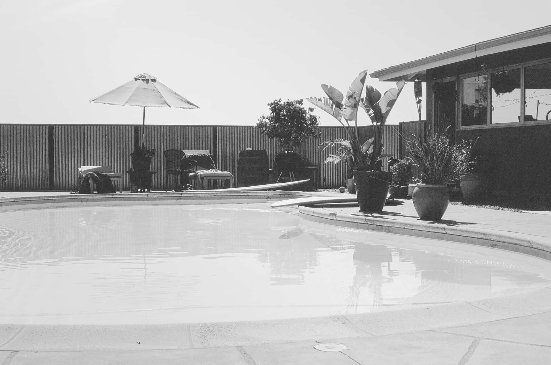 A backyard swimming pool with a fence around it