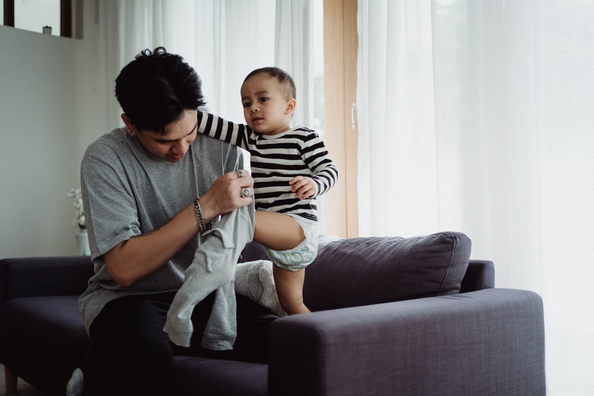 A baby pulling up to stand against a sofa