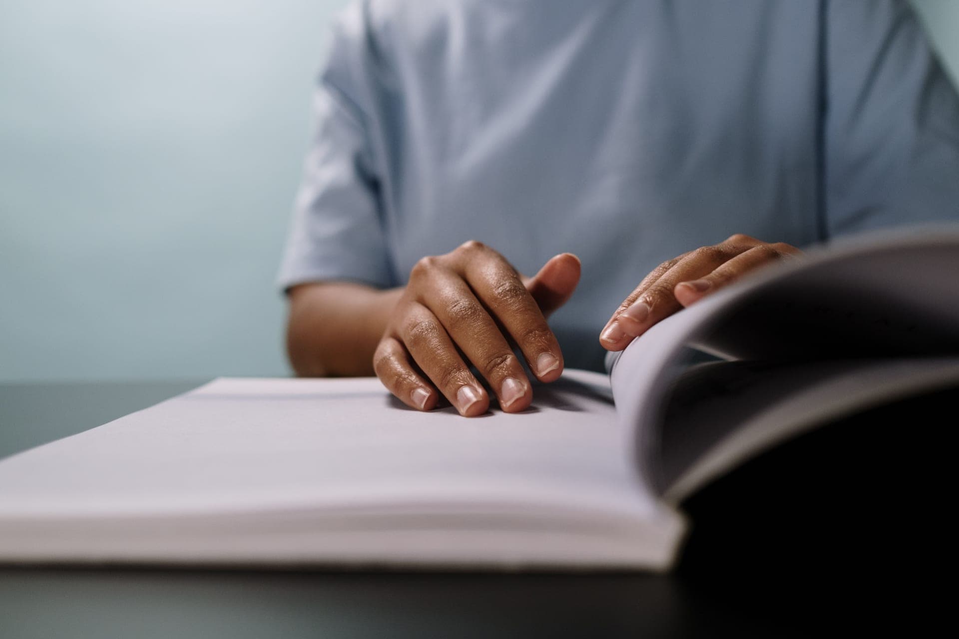 A person reading a printed instruction manual
