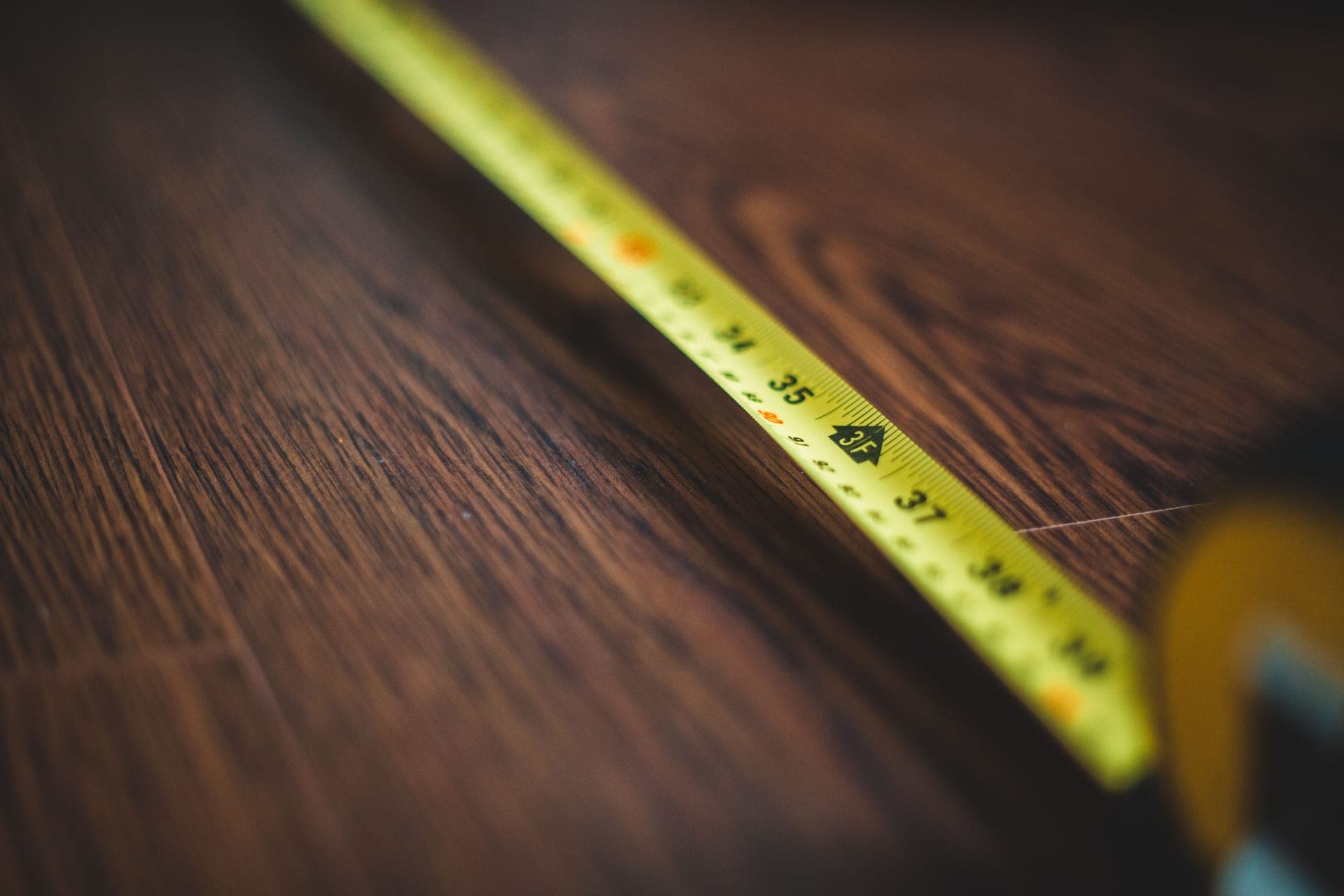 A tape measure held against a wooden surface
