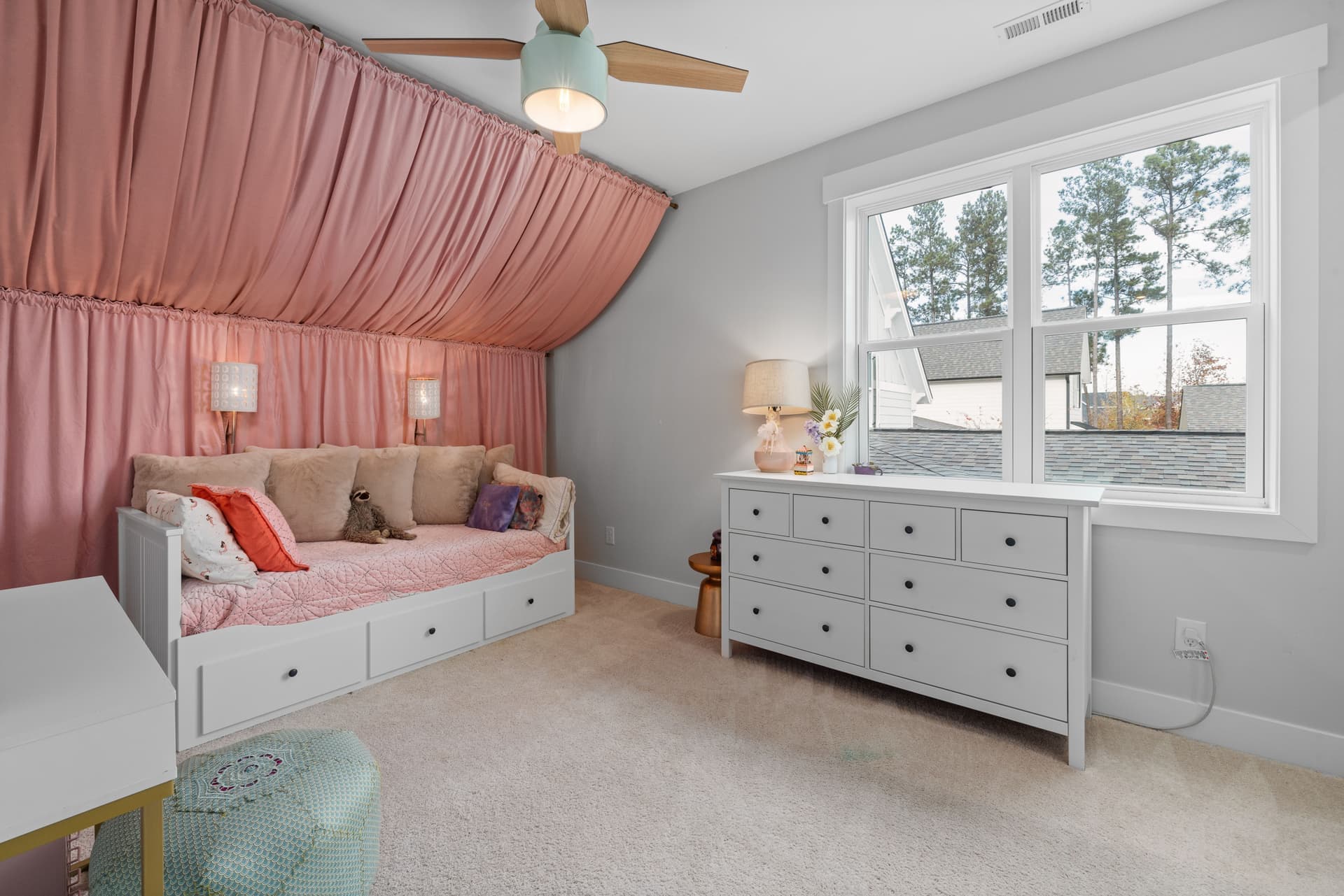 A tall white dresser with open drawers in a child's bedroom
