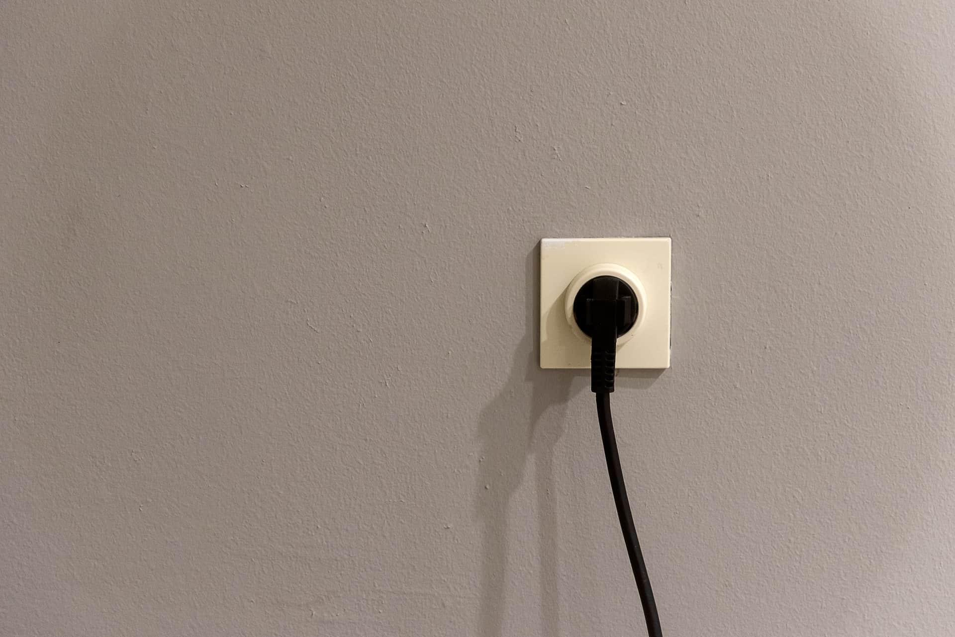 A power plug beside an electrical outlet